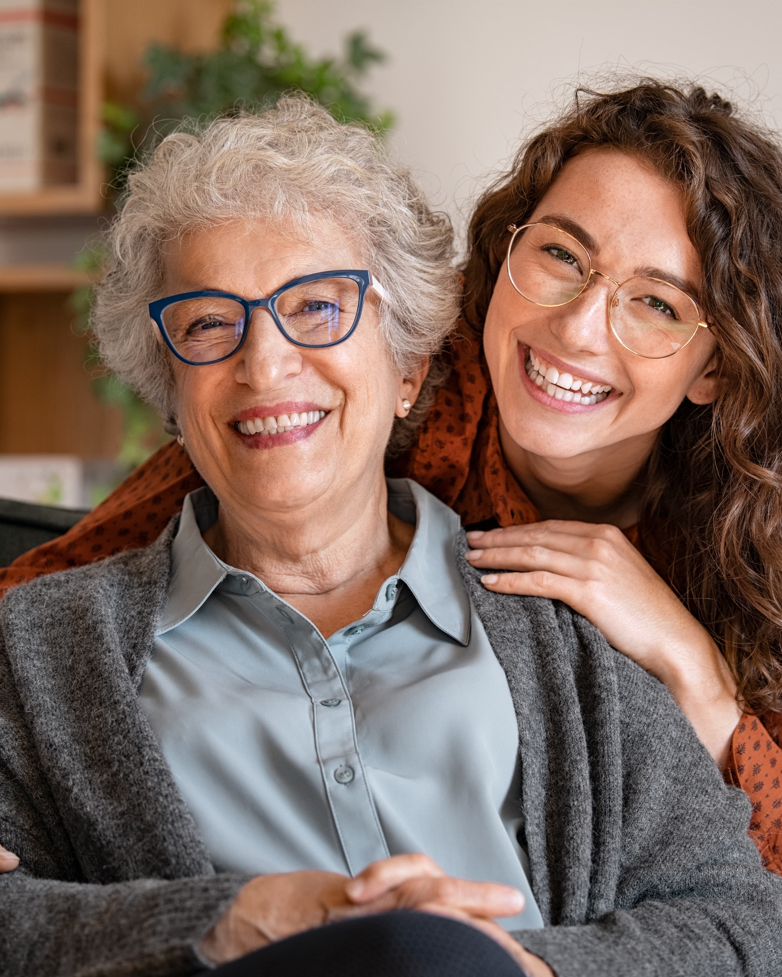 A smiling caregiver with an older adult client at home.